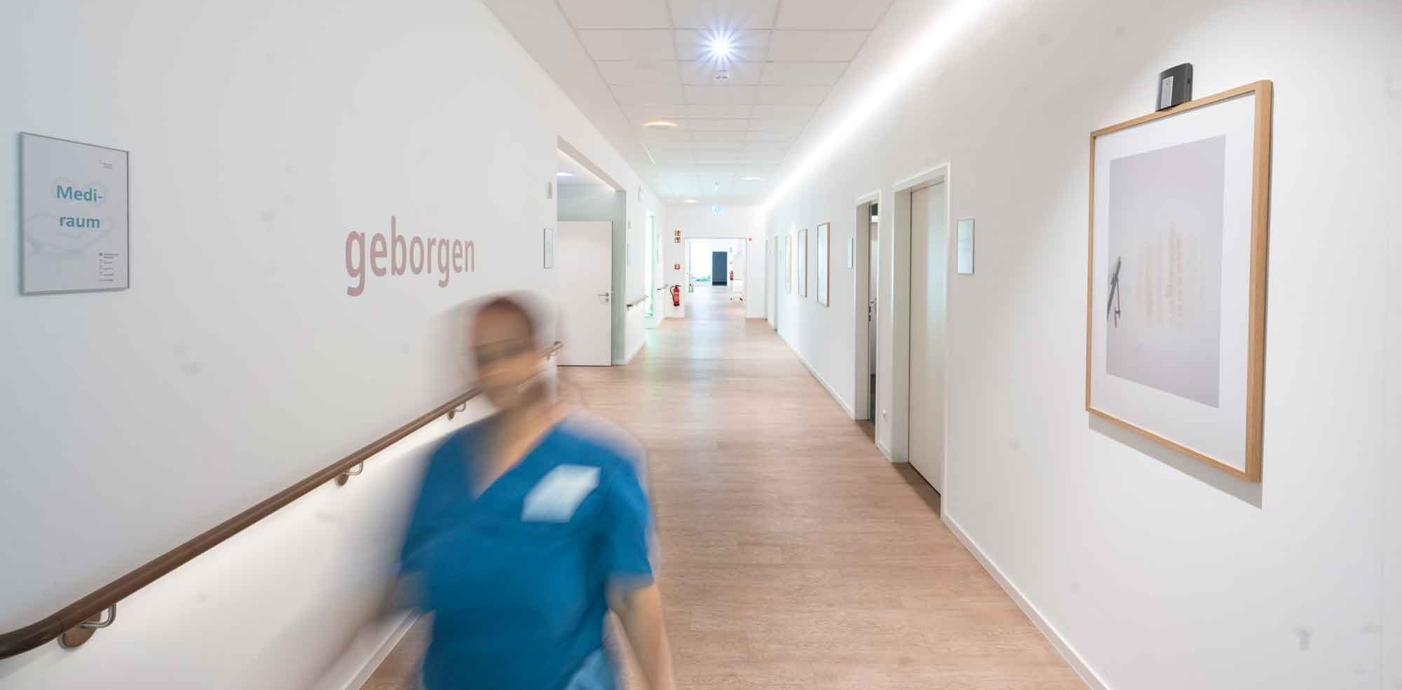 Pflegerin sitzt bei Seniorin welche Tee trinkt
