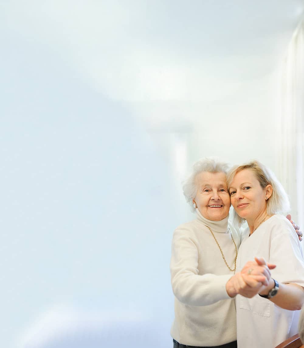 Stationäre Pflege – Schwester tanzt mit Seniorin